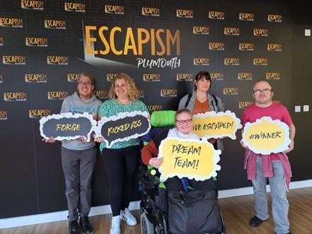 Photo of volunteer, Laura, with our Illumin8 group at an escape room event. 