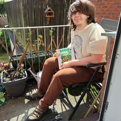 Michael sat in his garden with a book on gardening.