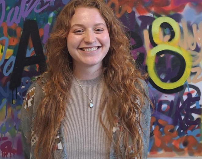 Woman stood in front of graffiti picture